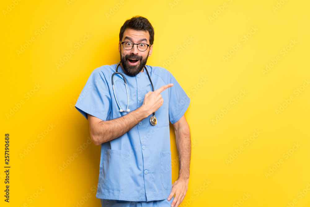 Surgeon doctor man surprised and pointing side Surgeon doctor man surprised and pointing side