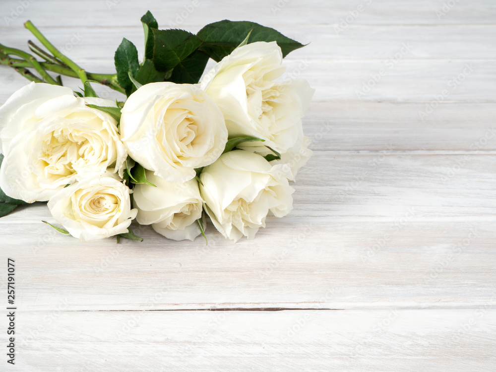 White roses on a white wooden table White roses on a white wooden table