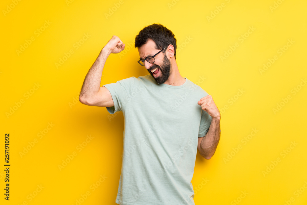 Man with beard and green shirt celebrating a victory Man with beard and green shirt celebrating a victory