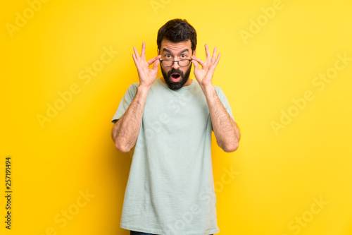 Man with beard and green shirt with glasses and surprised