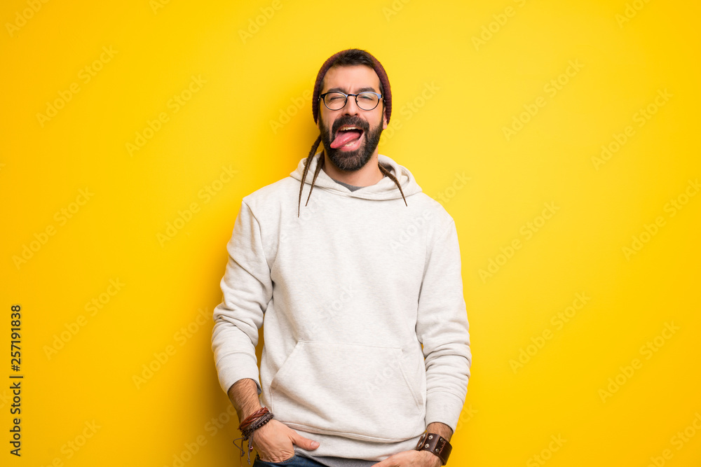Hippie man with dreadlocks showing tongue at the camera having funny look Hippie man with dreadlocks showing tongue at the camera having funny look