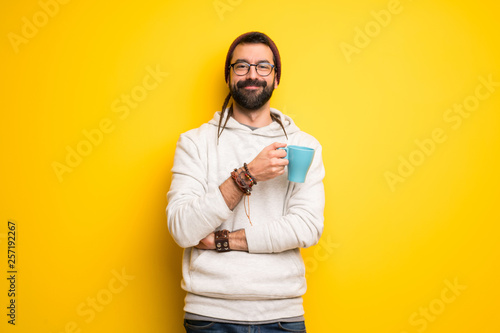 Canvas-taulu Hippie man with dreadlocks holding a hot cup of coffee