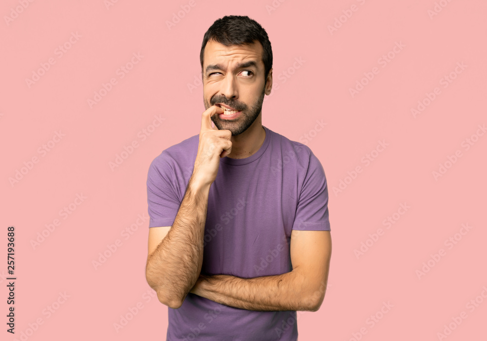 Handsome man having doubts while looking up on isolated pink background Handsome man having doubts while looking up on isolated pink background