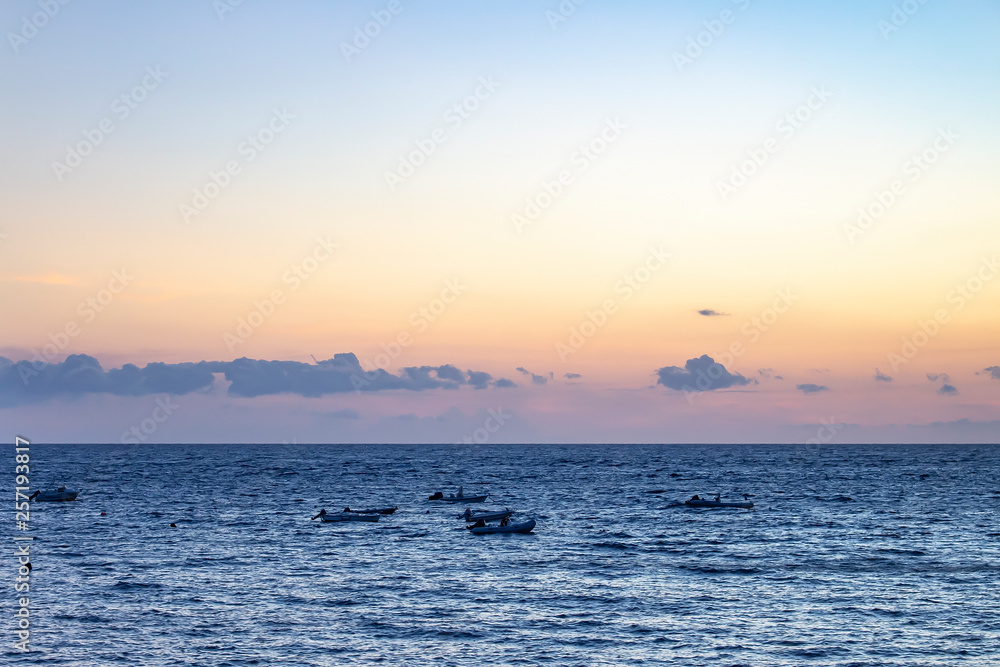 The abandoned fishing boats drifting in the sea during sunset along the coast of La Caleta, Costa Adeje on Tenerife, Spain The abandoned fishing boats drifting in the sea during sunset along the coast of La Caleta, Costa Adeje on Tenerife, Spain