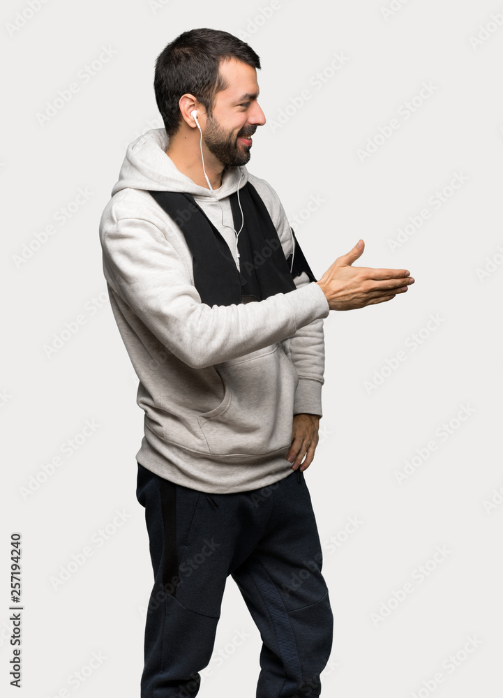 Sport man handshaking after good deal over isolated grey background Sport man handshaking after good deal over isolated grey background