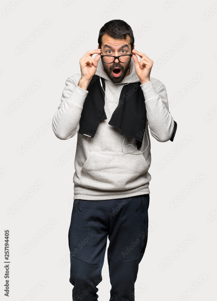 Sport man with glasses and surprised over isolated grey background Sport man with glasses and surprised over isolated grey background