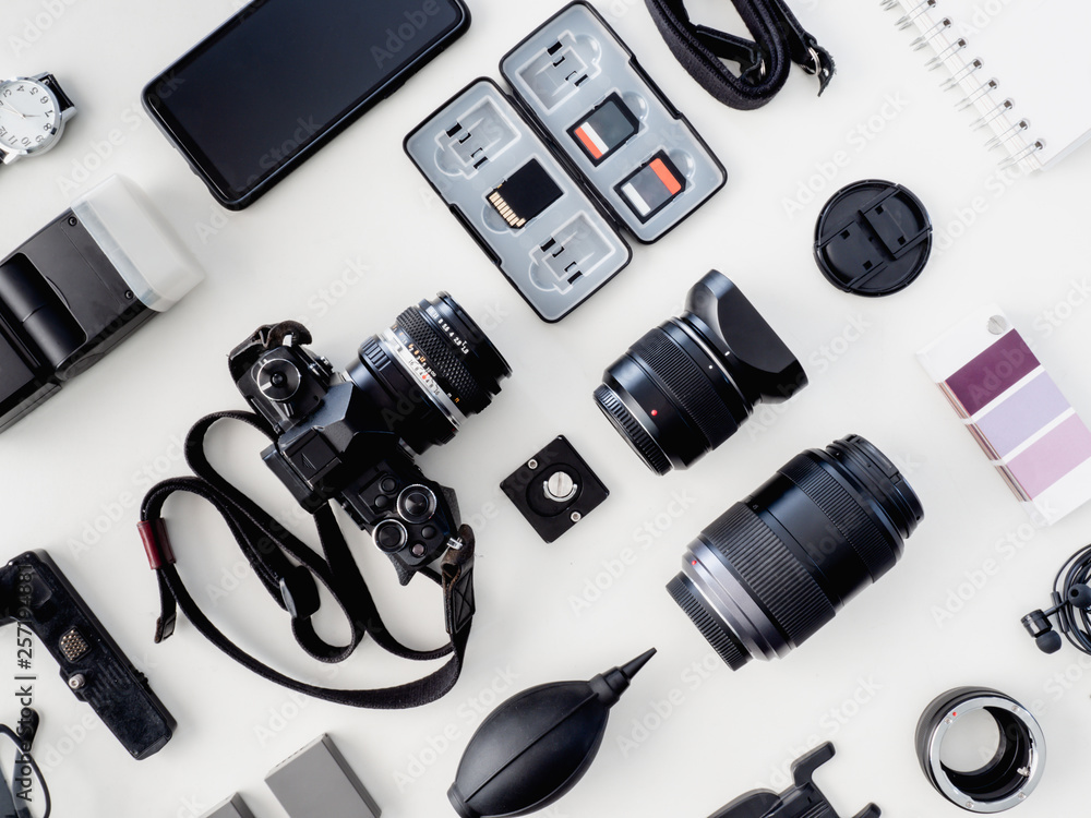 top view of work space photographer with digital camera, flash, cleaning kit and memory card on white table background. top view of work space photographer with digital camera, flash, cleaning kit and memory card on white table background.
