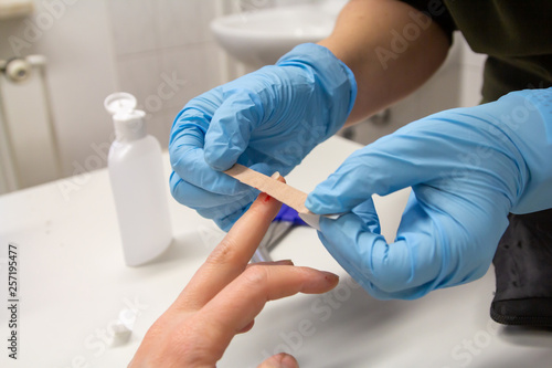 a doctor sticks a plaster on a finger