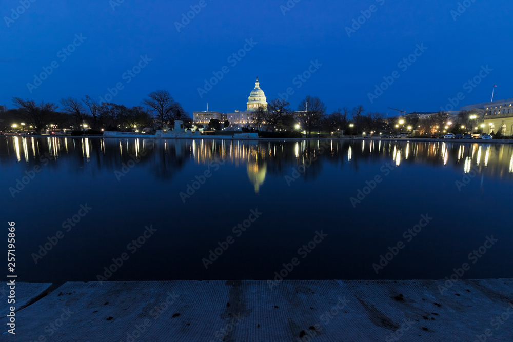 Spectacular night-time urban vista looking eastwards across the Capitol Reflecting Pool towards the illuminated United States Capitol building