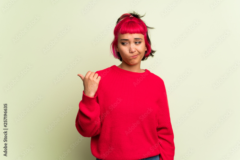 Young woman with red sweater unhappy and pointing to the side Young woman with red sweater unhappy and pointing to the side