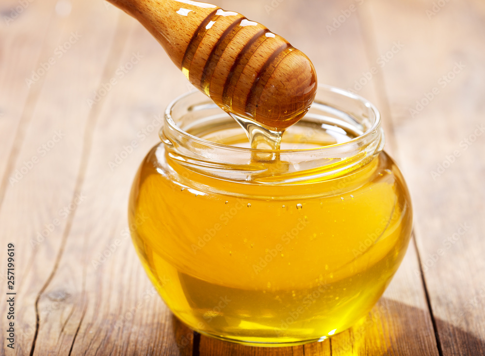pouring honey into jar