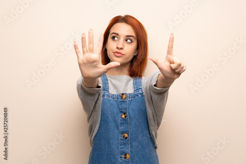 Young redhead woman over isolated background counting seven with fingers