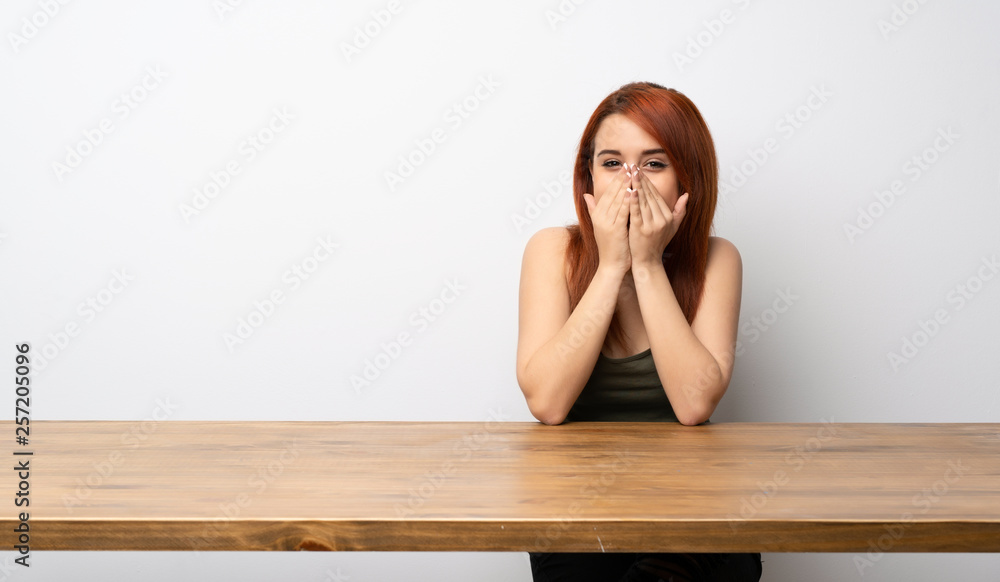 Young redhead woman at desk smiling a lot Young redhead woman at desk smiling a lot