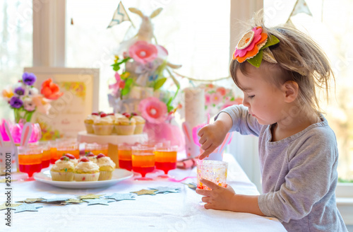 Little toddler girl eating dessert after Easter dinner