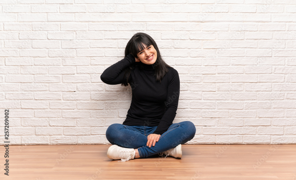Woman sitting on the floor smiling Woman sitting on the floor smiling
