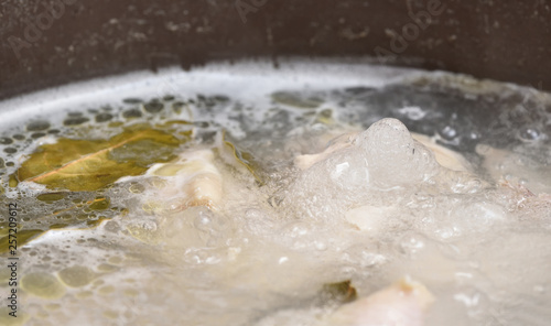 Transparent and fatty broth boils and boils in a saucepan. Close-up