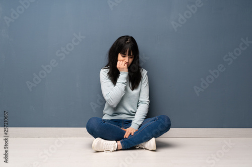 Woman sitting on the floor having doubts © luismolinero