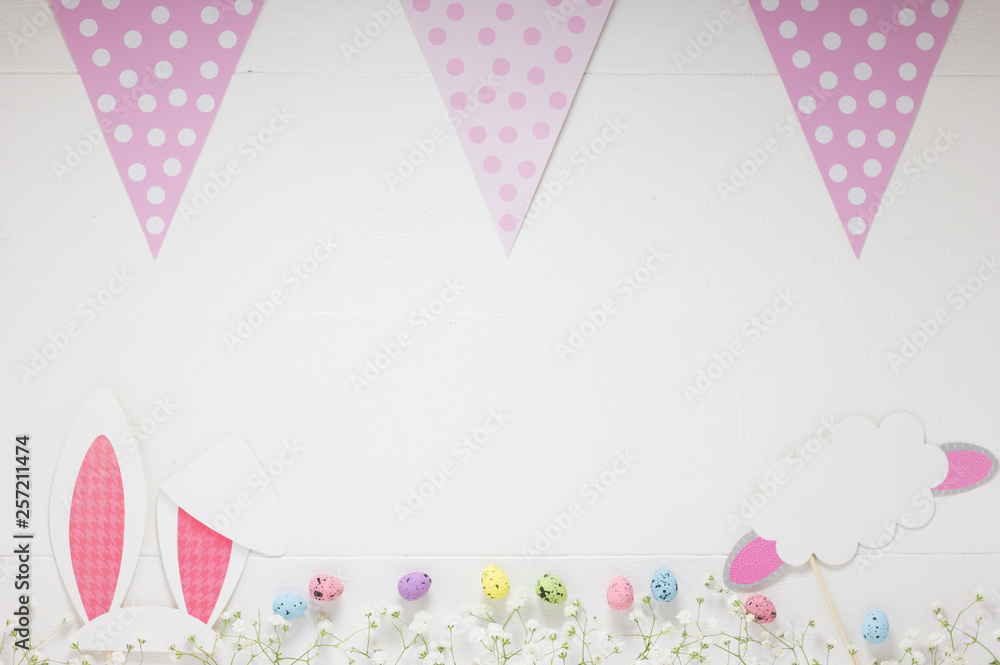 Mockup of White Festive Wooden Board with Easter Decorations along Lane of Flowers and Pink Flags Polka Dot Pattern. Concept: Happy Easter Empty Note.