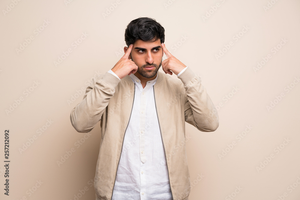 Young man over isolated wall having doubts and thinking Young man over isolated wall having doubts and thinking