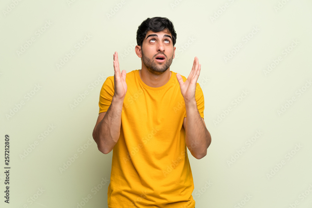 Young man over pink wall frustrated by a bad situation