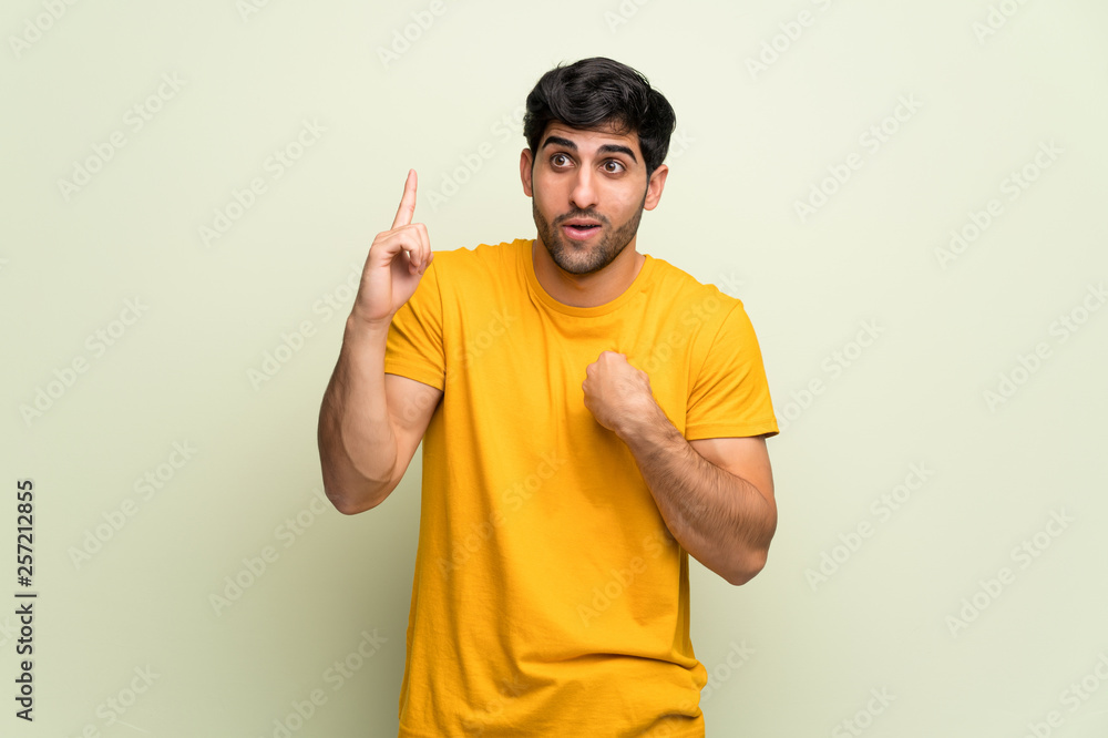 Young man over pink wall with surprise and shocked facial expression Young man over pink wall with surprise and shocked facial expression