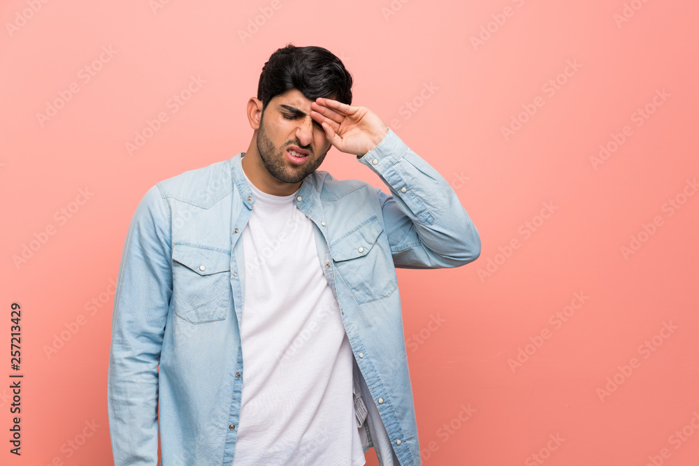 Young man over pink wall with tired and sick expression Young man over pink wall with tired and sick expression