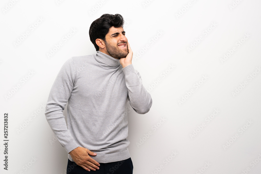 Young man over isolated white wall with toothache Young man over isolated white wall with toothache