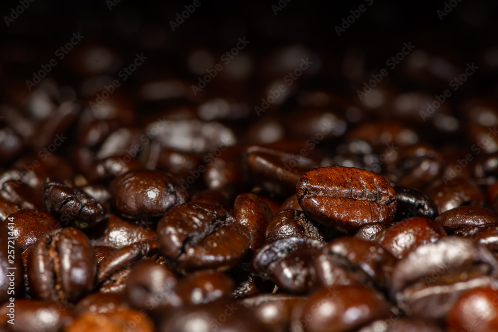 Dark brown roasted coffee beans under artificial light for background Dark brown roasted coffee beans under artificial light for background