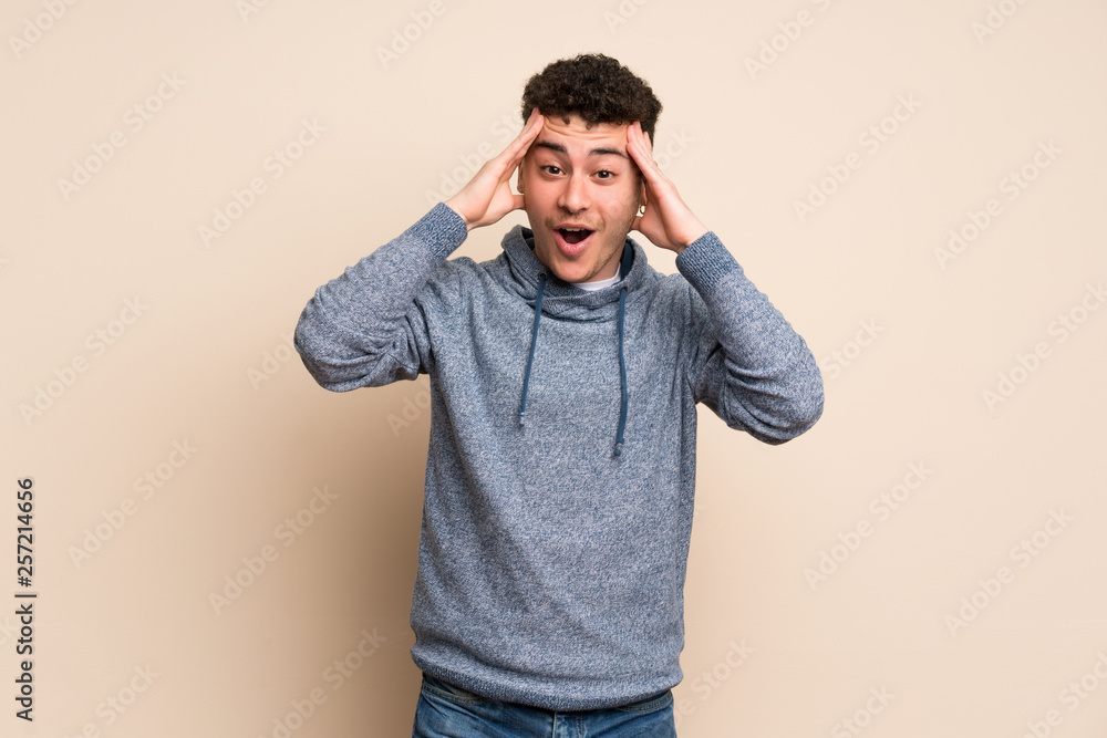 Young man over isolated wall with surprise expression Young man over isolated wall with surprise expression