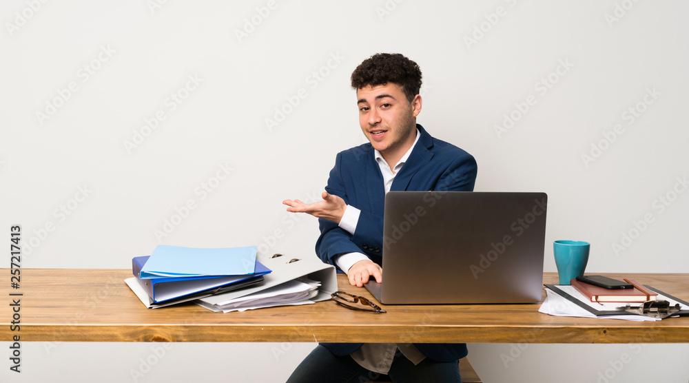 Business man in a office presenting an idea while looking smiling towards Business man in a office presenting an idea while looking smiling towards