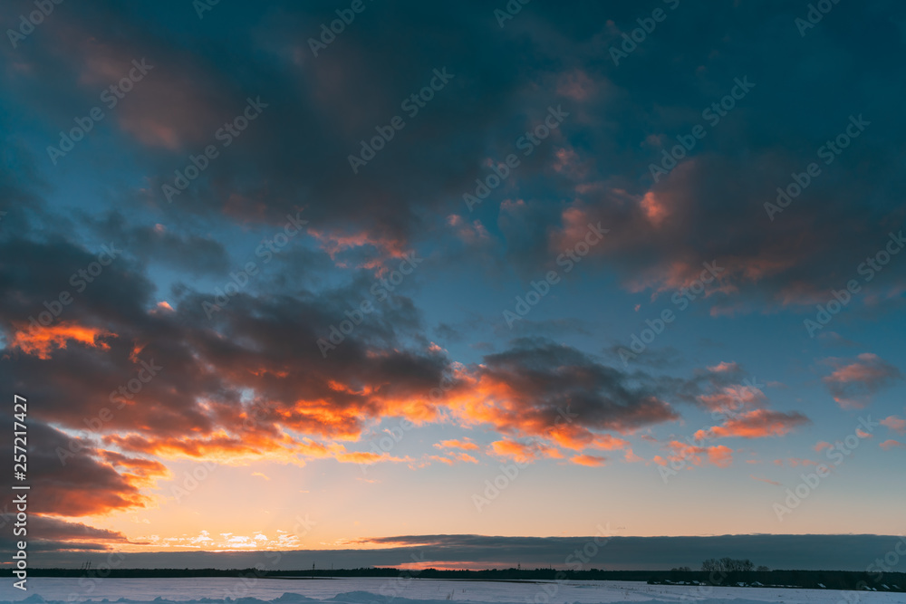 Natural Sunset Sunrise Over Field Or Meadow. Colorful Sky Over Winter Snowy Ground. Landscape Under Scenic Sky At Sunset Dawn Sunrise. Skyline, Horizon