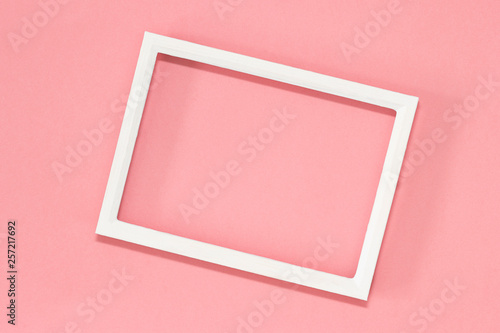 White frame for text on pink pastel background. Top view, flat lay.