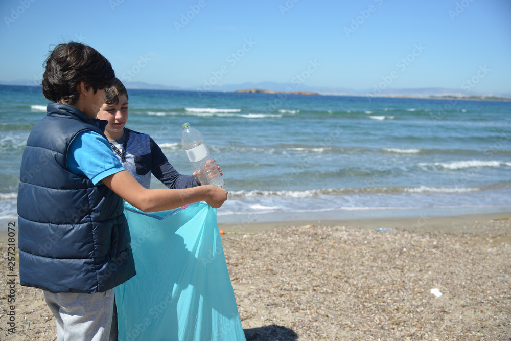 Two boys recycling plastic bottles and leftovers near the beach Two boys recycling plastic bottles and leftovers near the beach