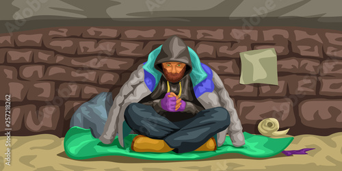 homeless man sitting at wall