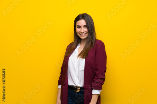 Young woman over yellow wall