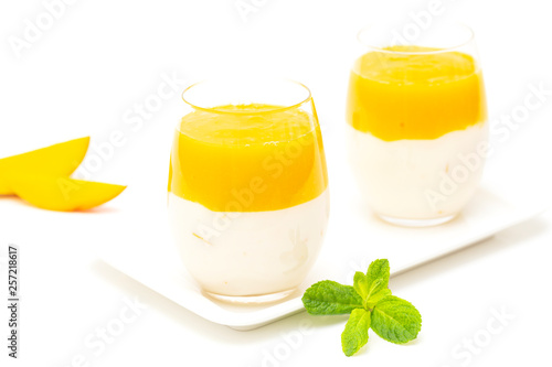 Fruit dessert with mango and mint over white background. Mango mousse. Italian dessert, homemade cuisine. 