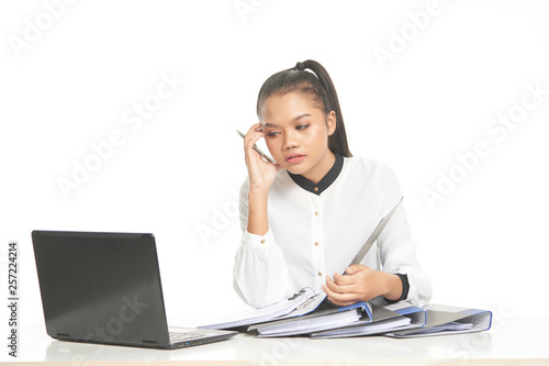 Office lady in white shirt and ponytail hair using a laptop and file