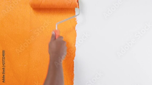 Painting of walls in a oranges color for repair old paint in a house photo