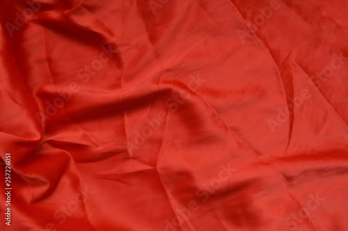 Photo - texture, fabric silk red, in abstract style. Beautiful background.