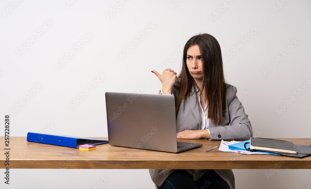 Business woman in a office unhappy and pointing to the side Business woman in a office unhappy and pointing to the side