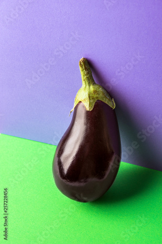 Dark purple eggplant on duotone violet green background. Conceptual trendy image creative food poster. Healthy balanced diet vegan clean eating concept. Poster with copy space