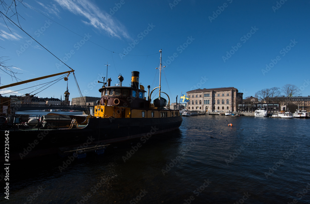 A sunny spring day in Stockholm, view over a pier with boats and birds at the city and old town A sunny spring day in Stockholm, view over a pier with boats and birds at the city and old town