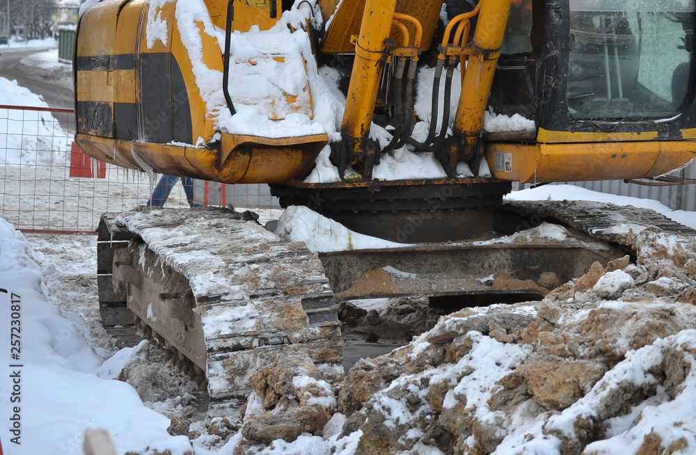 Excavator close up. Repair work in the winter on the street. Russia. Excavator close up. Repair work in the winter on the street. Russia.