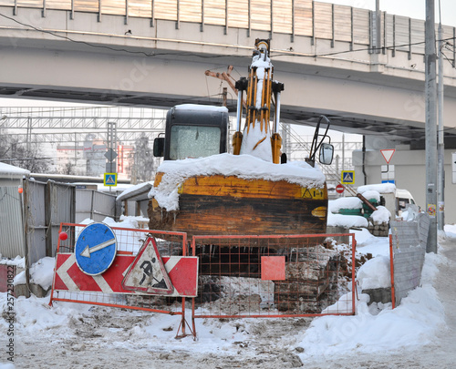 Excavator close up. Repair work in the winter on the street. Russia.