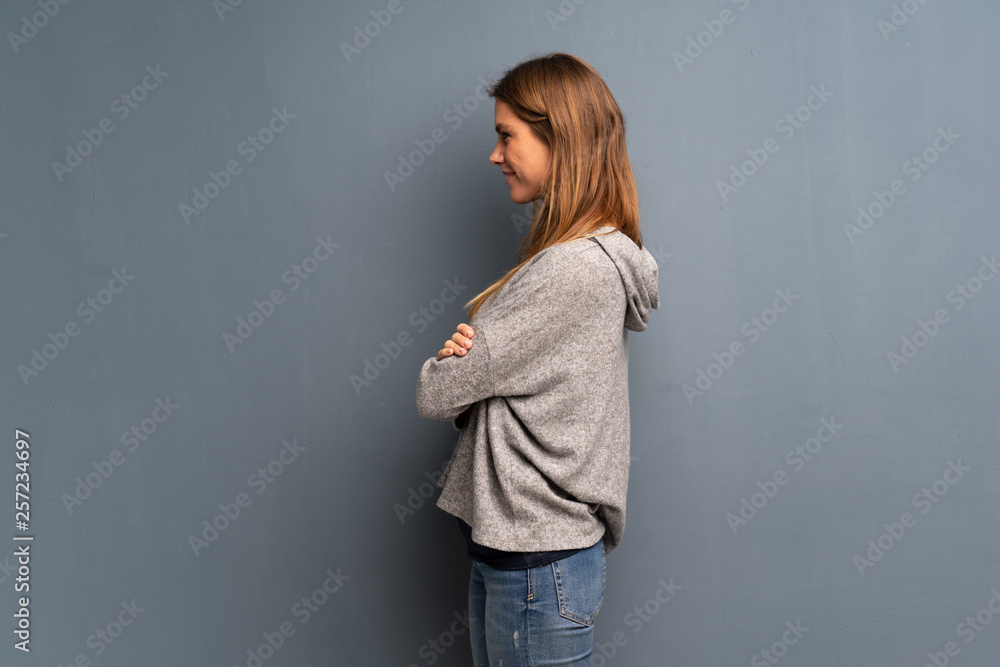 Blonde woman over grey background in lateral position Blonde woman over grey background in lateral position