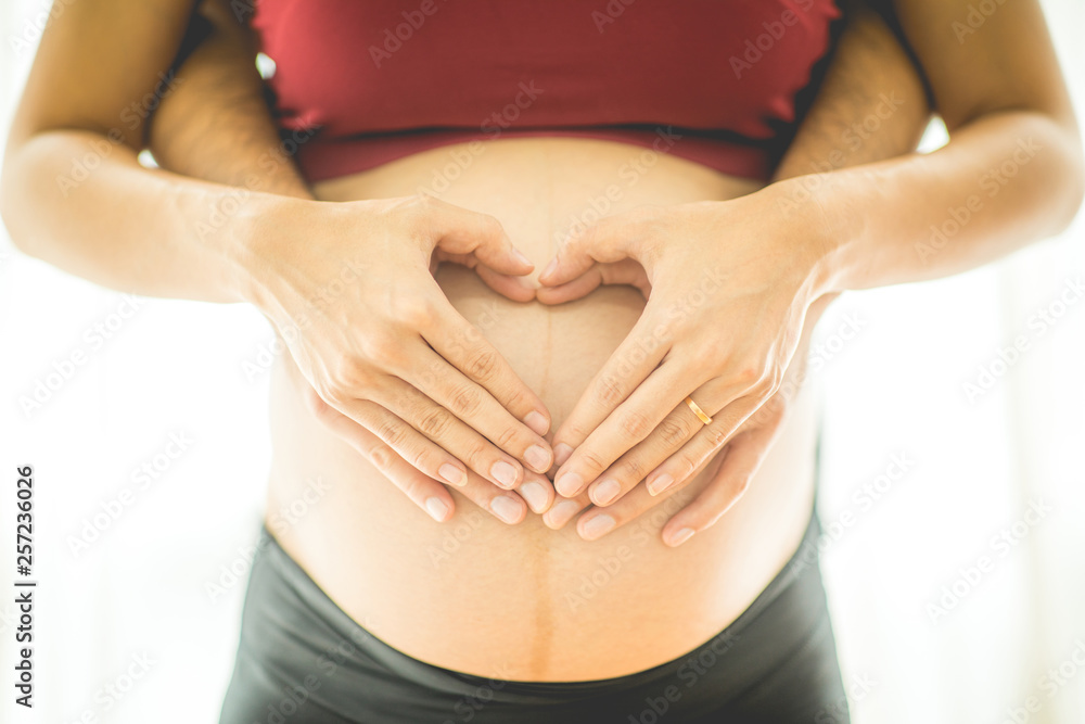 Close up pregnant woman and husband hugging the tummy and making shaping a heart on belly for love and happiness,Healthy Pregnant Concept,Selective Focus,warm tone Close up pregnant woman and husband hugging the tummy and making shaping a heart on belly for love and happiness,Healthy Pregnant Concept,Selective Focus,warm tone