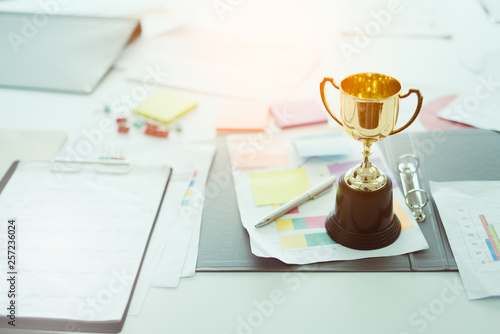 champion golden trophy on table.Award trophy on working table with document and contract