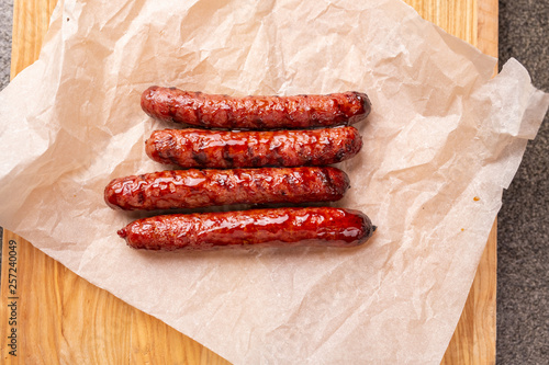 food, delicious and serving concept - grilled sausages on wooden board