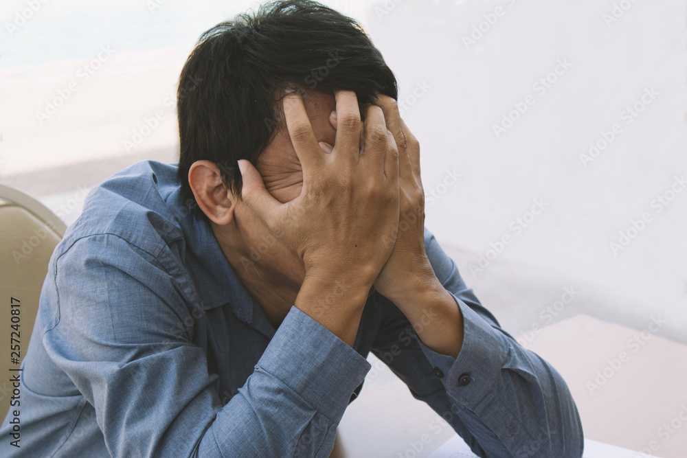 Young manager feel stress and put his 2 hands on his face; depressed business concept Young manager feel stress and put his 2 hands on his face; depressed business concept