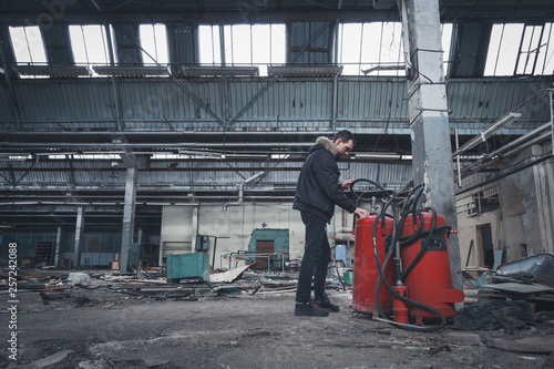 Old factory building and fire inspector with a fire extinguisher. Fire safety